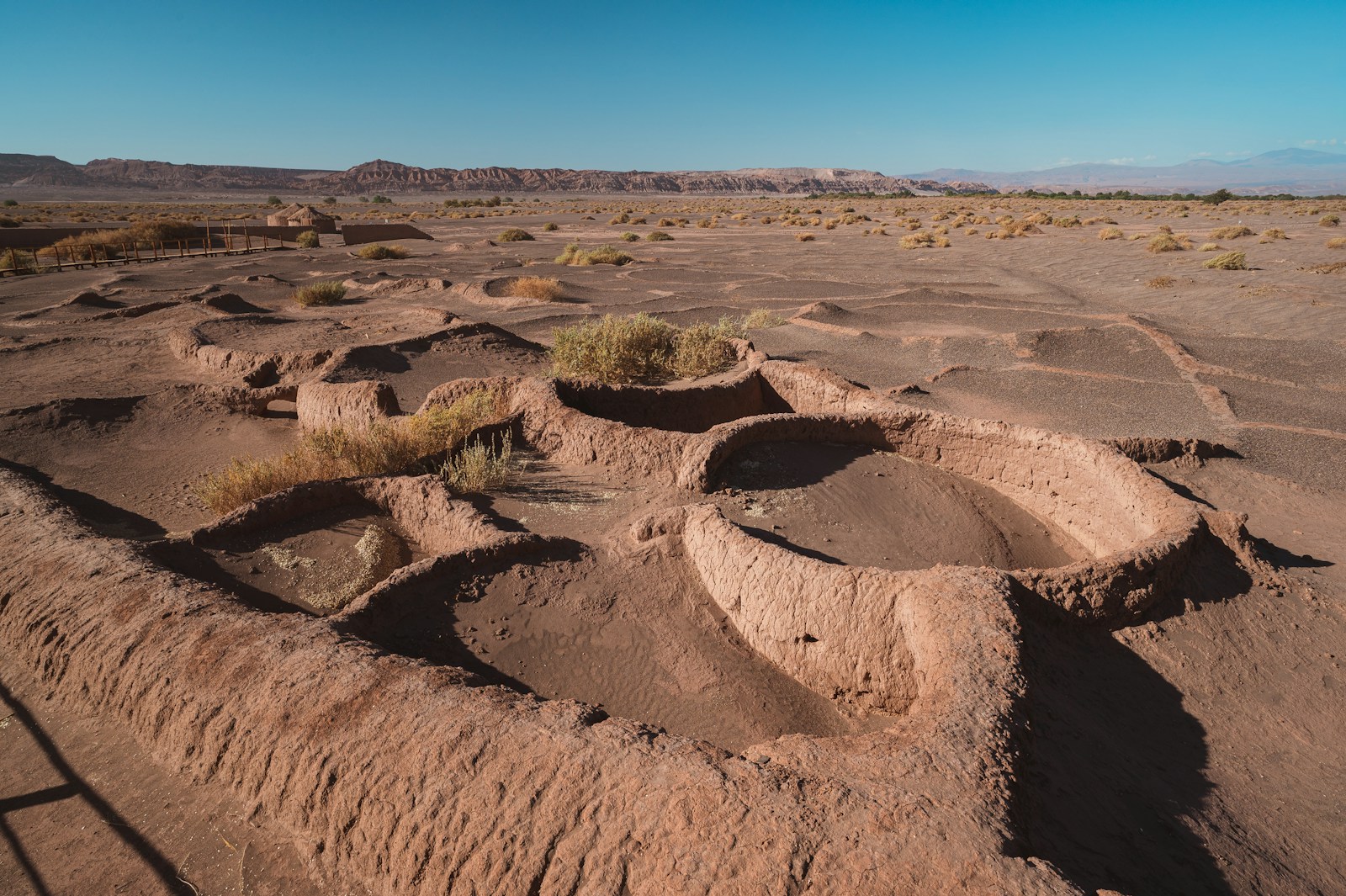 Ancient circular ruins in a dry, desert landscape.